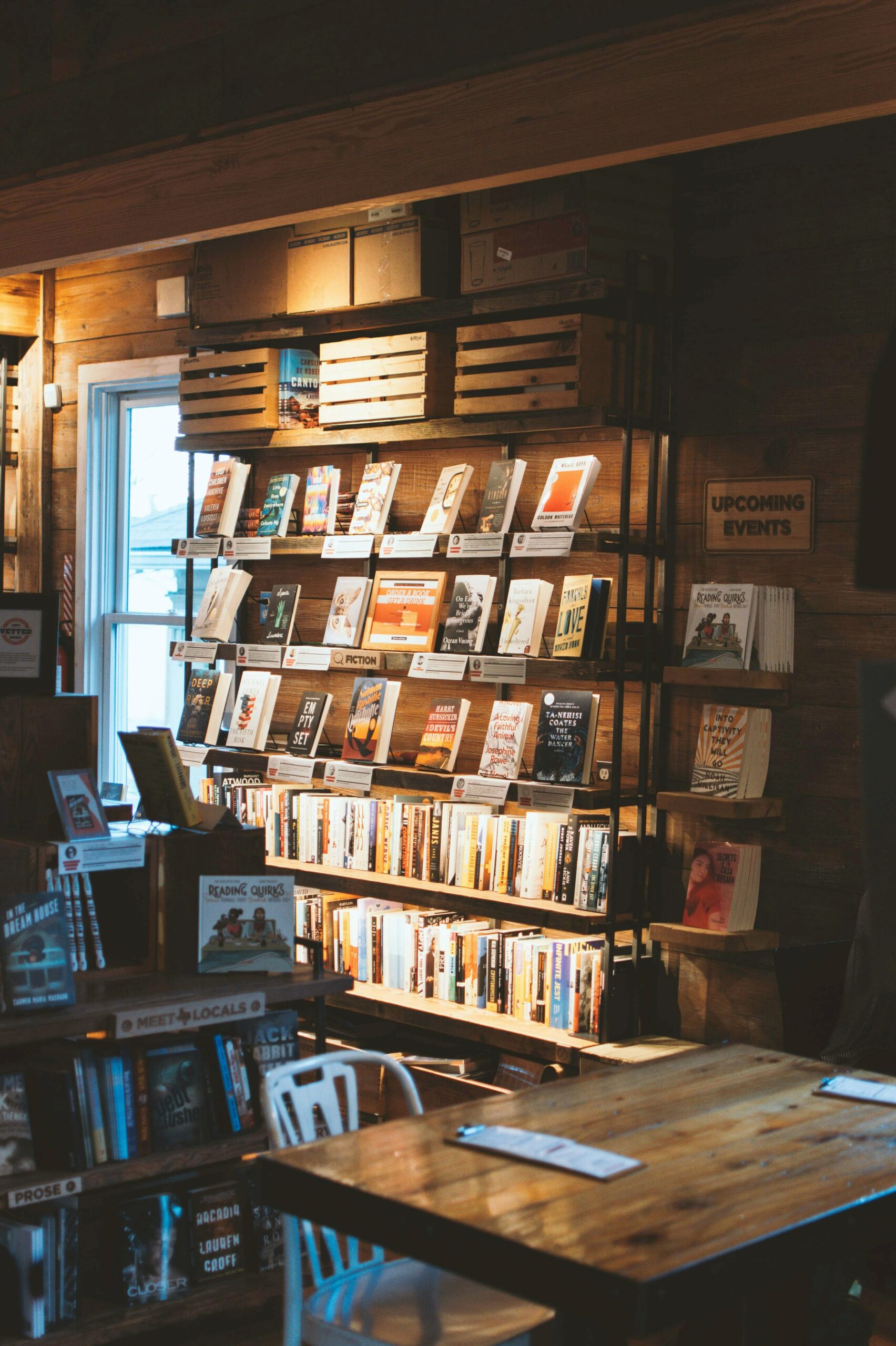 Books on display shelf under dim lighting in a bookstore