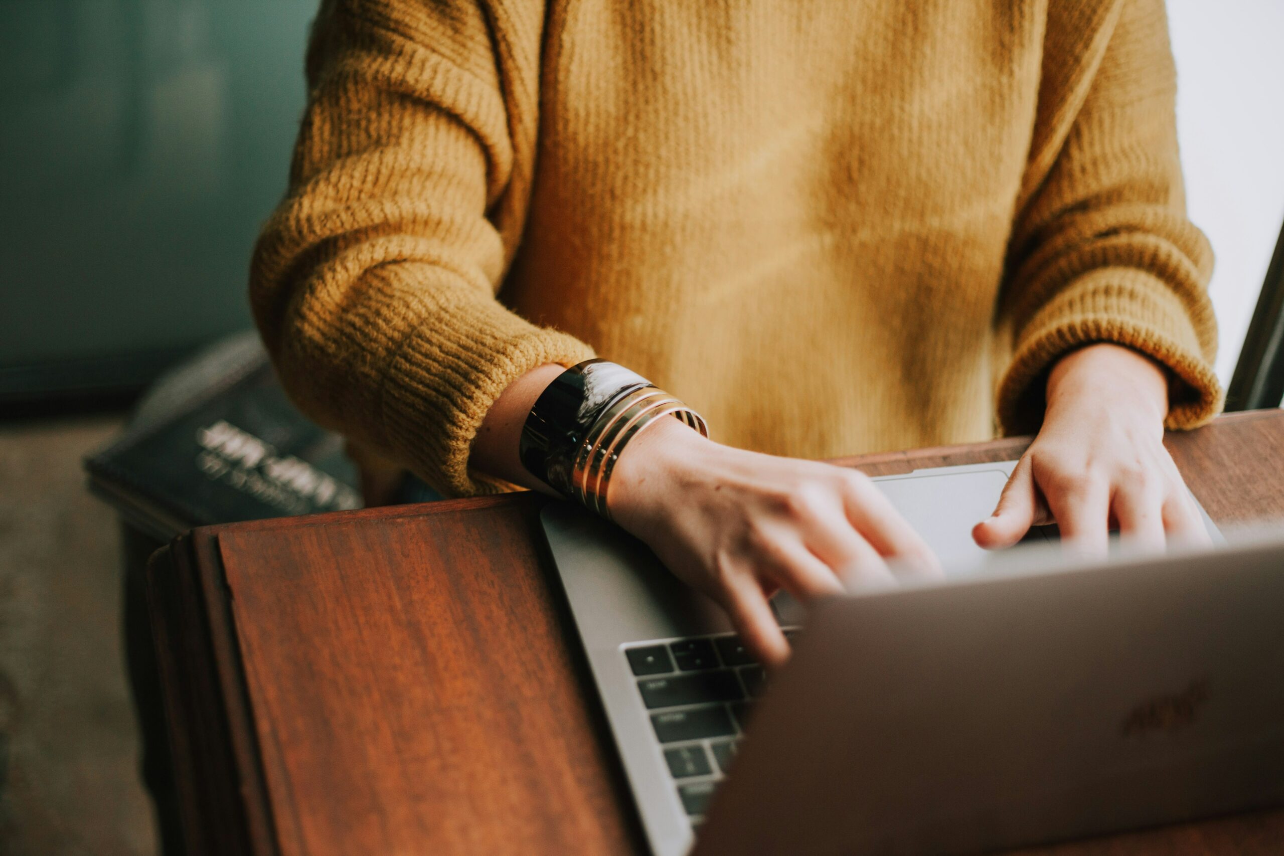 Person at table typing on computer