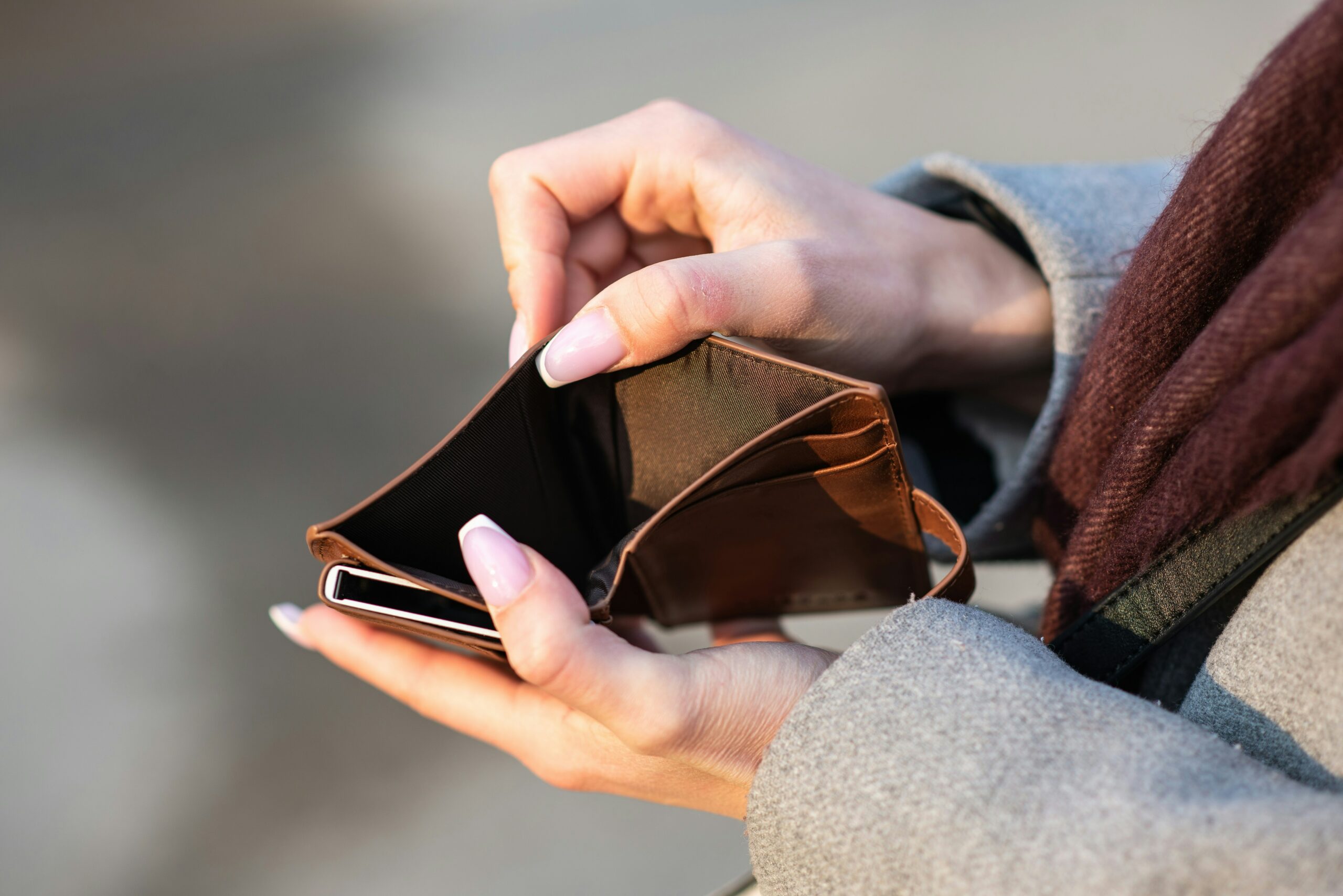 person holding empty brown wallet