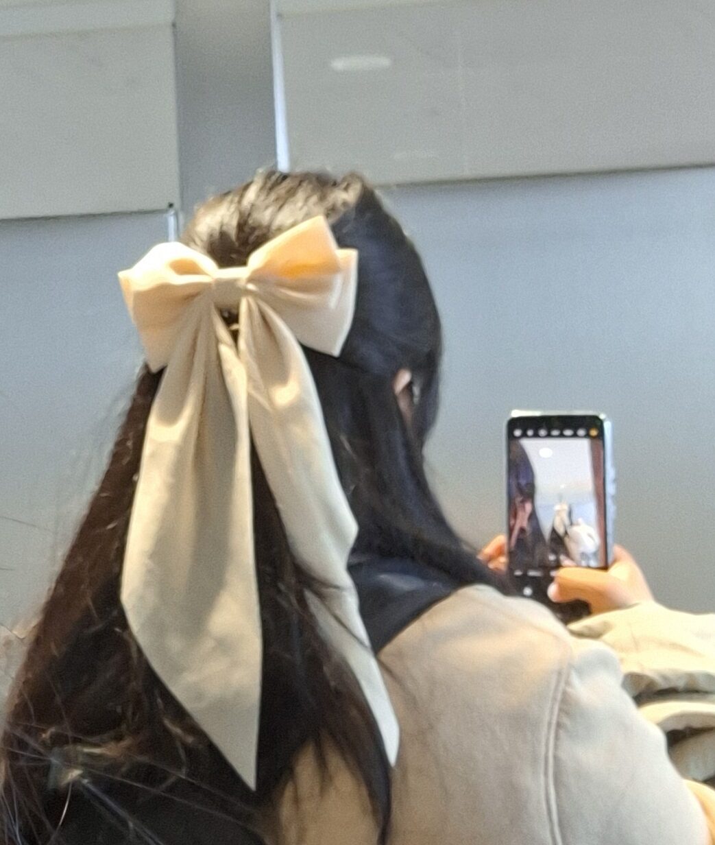 Person wearing light coloured bow in hair