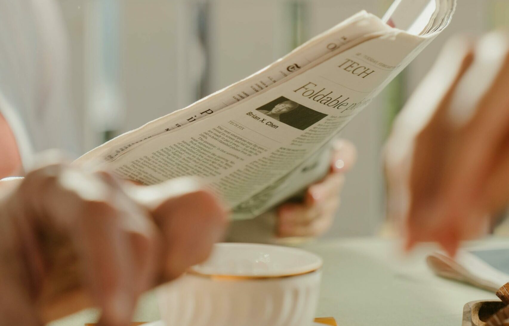 Person holding white newspaper